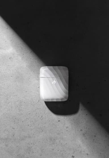 A closed frosted ZIZO Halos charging case on dark concrete