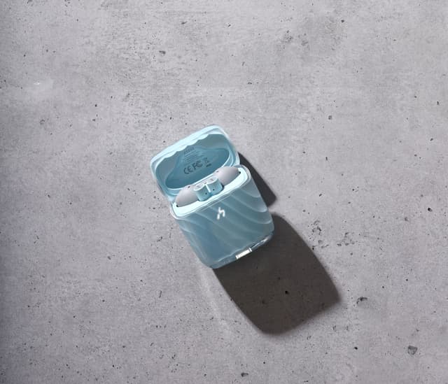 A pale blue translucent ZIZO Halos charging case, open, on gray concrete in hard sunlight