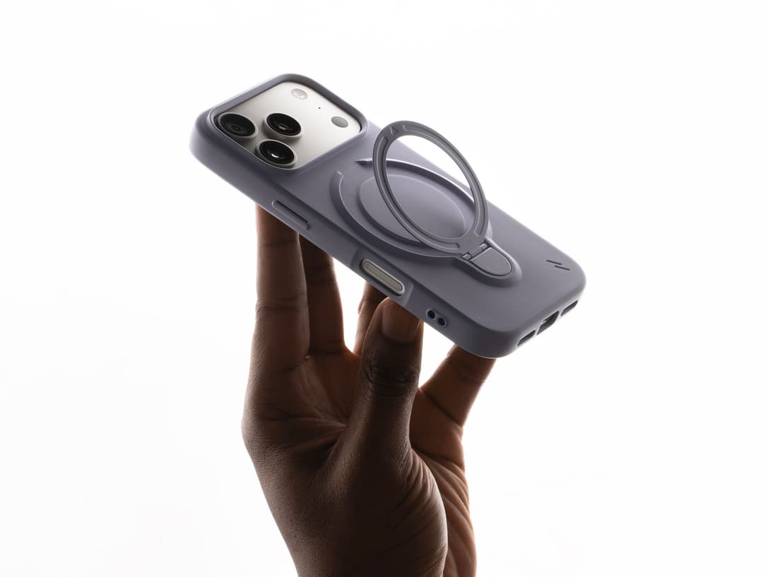 ZIZO Revolve case in muted lavender-gray on an iPhone Pro, held in hand with the built-in ring flipped open into kickstand mode
