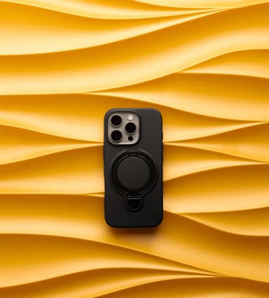 A black ZIZO Revolve case on an iPhone with its ring popped open into a stand, on rippling golden fabric